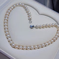 Pearl necklace with a heart-shaped clasp on a white heart-shaped box