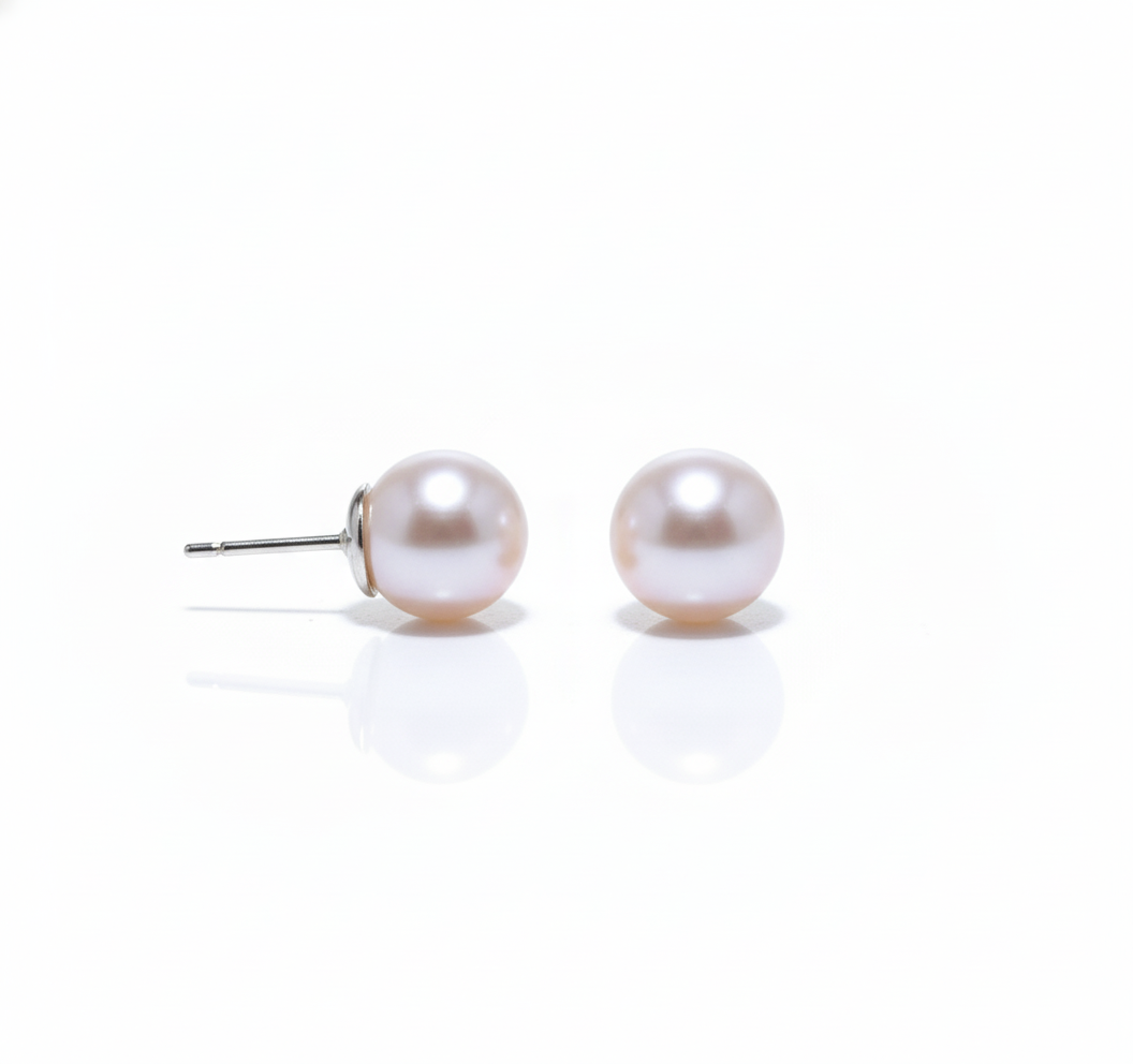 Side view of pearl stud earrings on white background