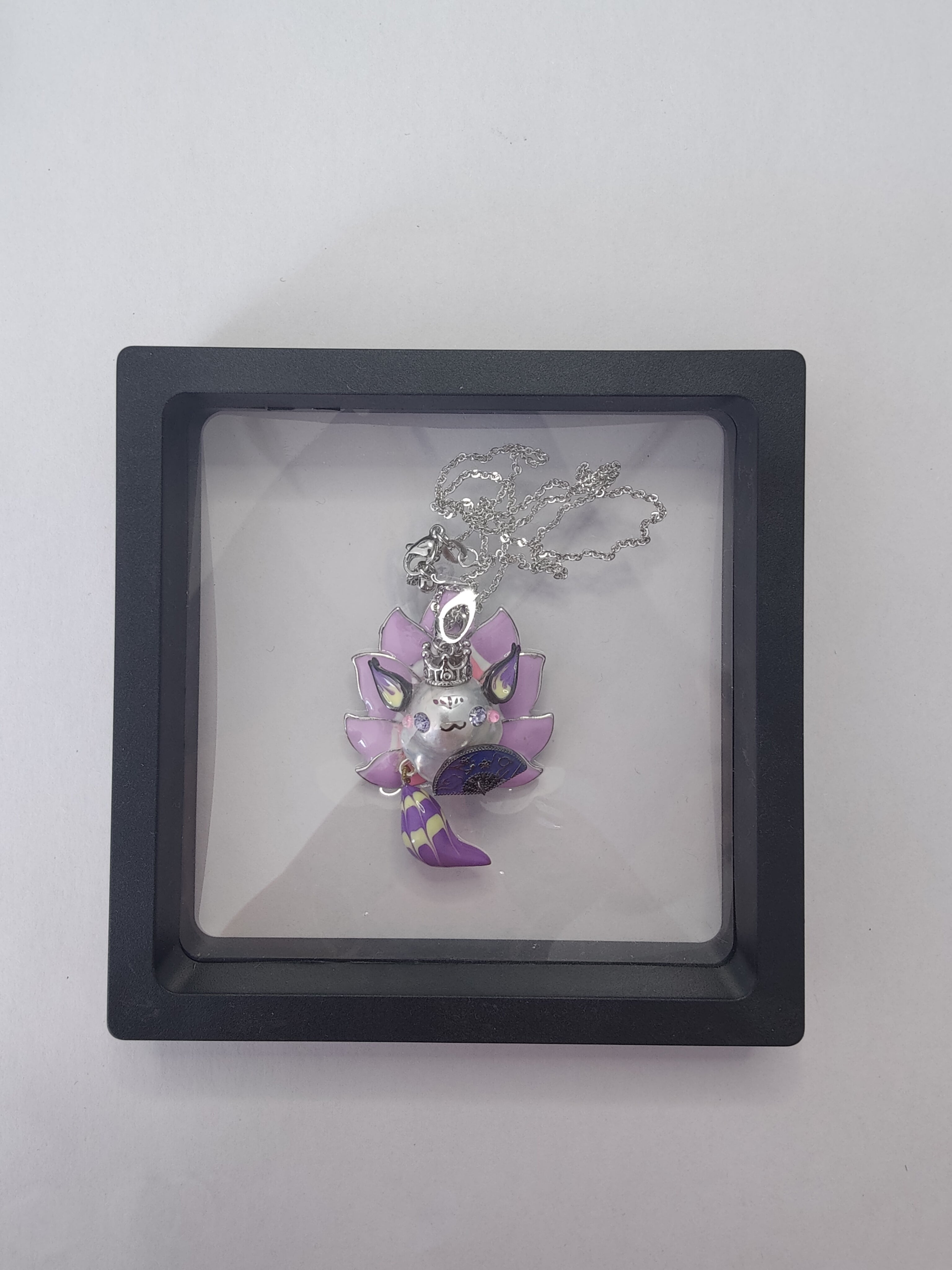 Baroque pearl fox pendant displayed on clear jewelry packaging box