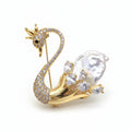 Gold swan brooch with pearls and gemstones on a white background