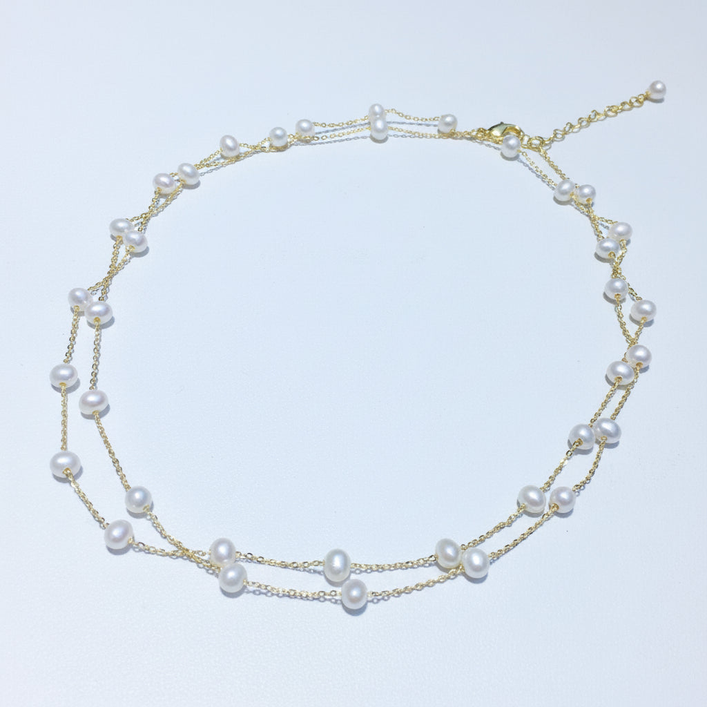 Double-layered pearl necklace on a light background