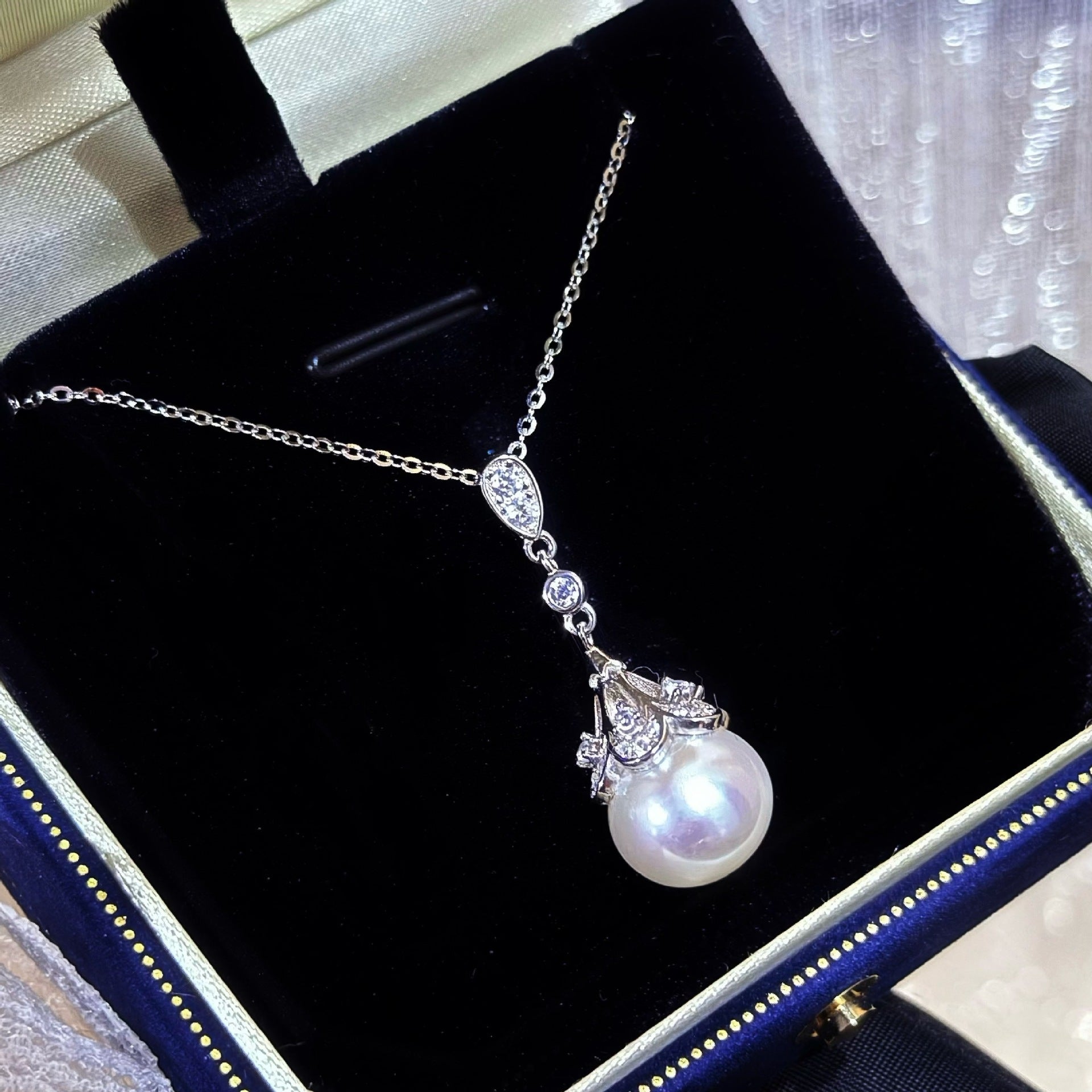 Pearl necklace with silver chain in a jewelry box